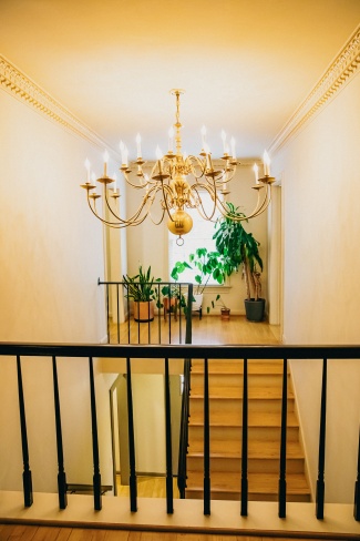 A balcony overlooking the main staircase in the foyer with a chandelier